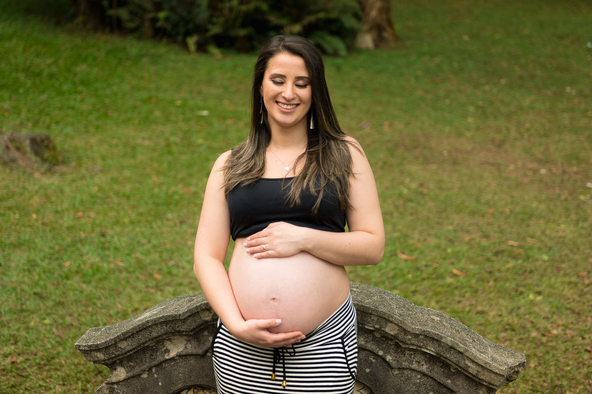 mulher gestante em pé no jardim botânico em são paulo